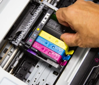 Mano cambiando tinta de la impresora